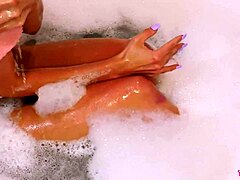 美丽的金发女郎在放松的浴缸中展示完美无瑕的体质